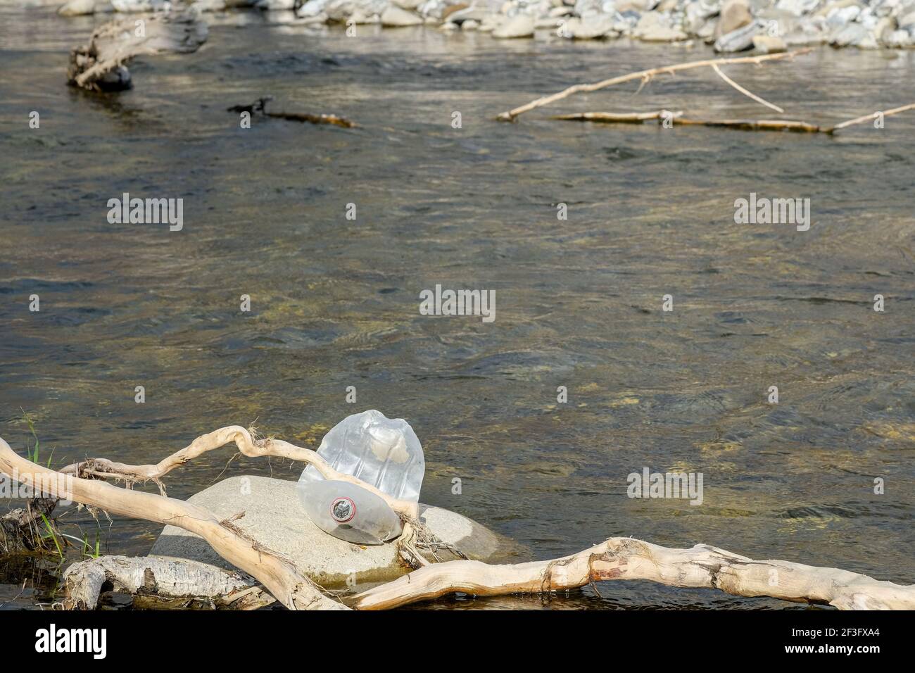 Scartato bottiglia di plastica spazzatura inquinamento su ecosistema di fiume di montagna contaminato, ambientale rifiuti Foto Stock