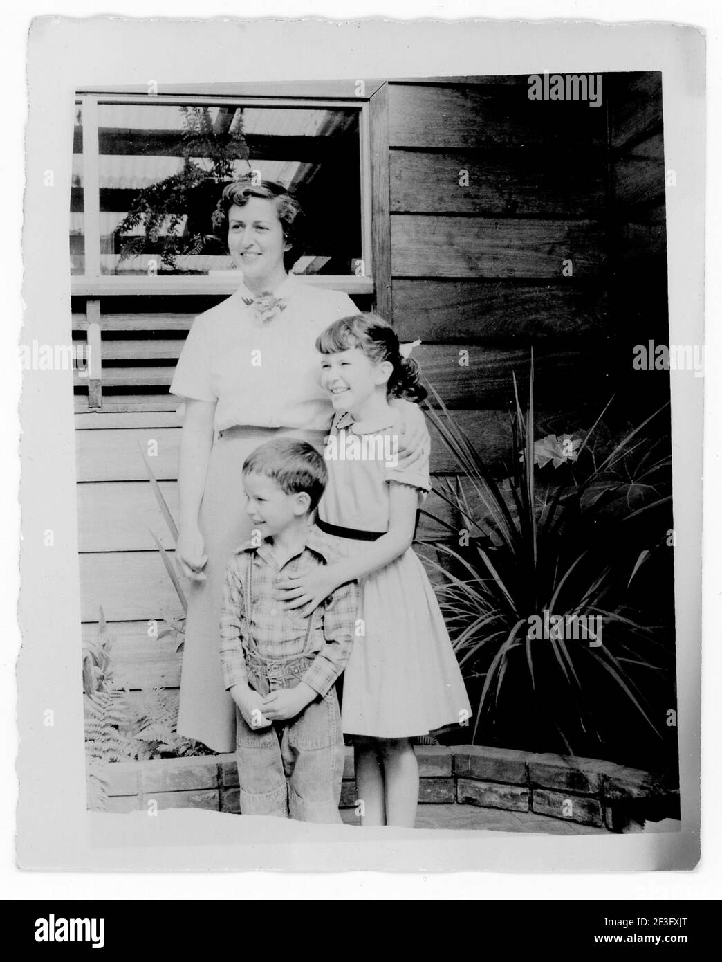 Madre e suo figlio e figlia posa fuori Middle Class House, 1950, Stati Uniti Foto Stock