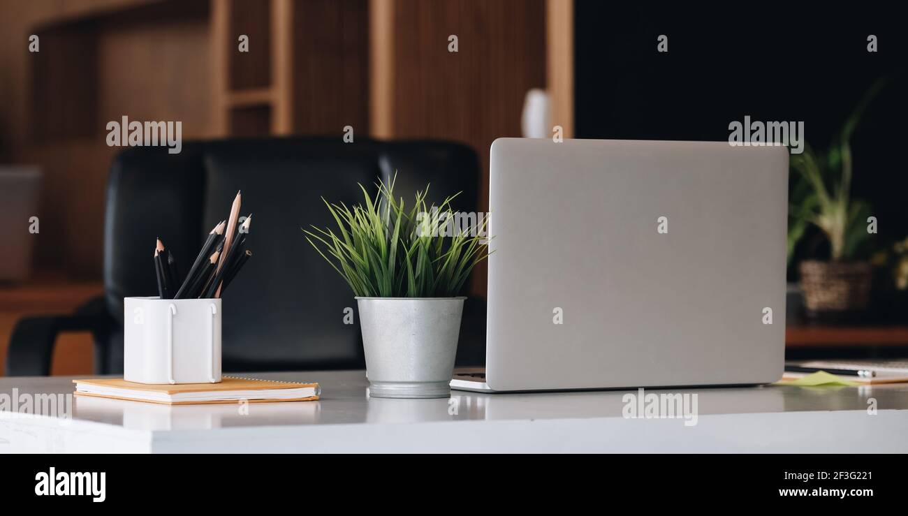 Computer portatile all'interno della scrivania dell'ufficio. Elegante mockup sul posto di lavoro Foto Stock
