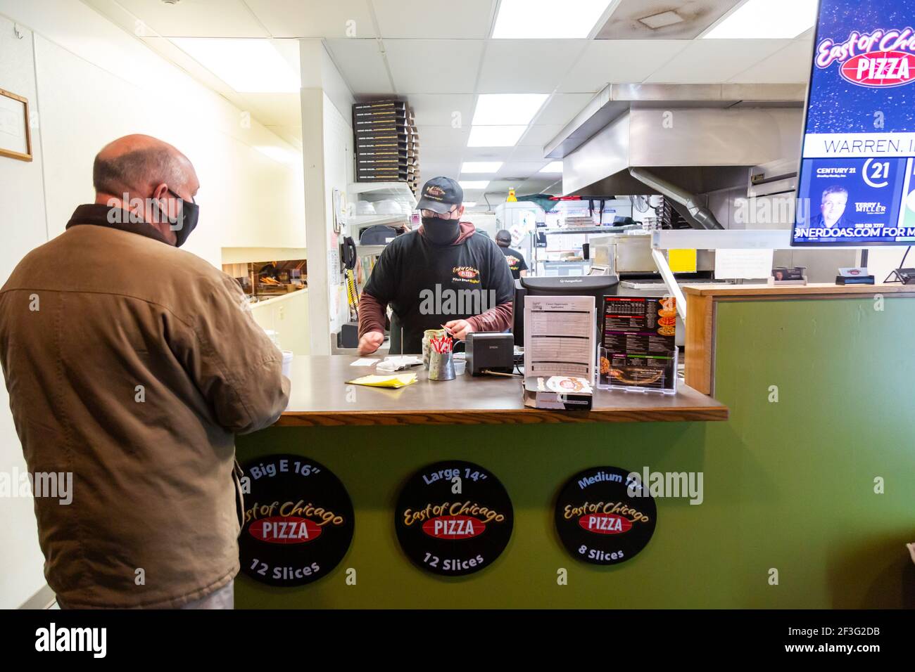 Un cliente mascherato paga il suo conto al ristorante East of Chicago a Warren, Indiana, USA. Foto Stock