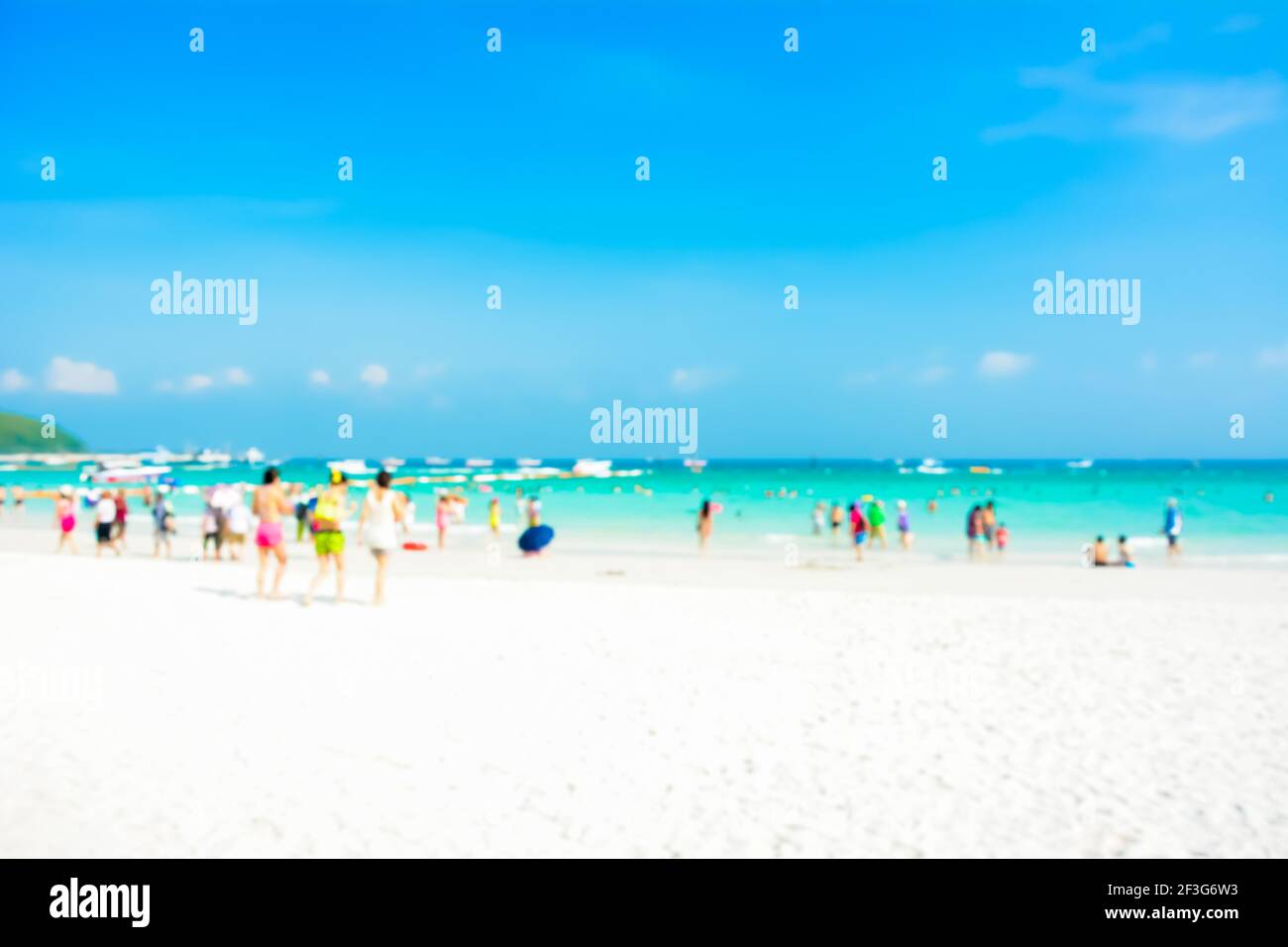 Sfumata la gente sulla spiaggia di sabbia bianca con mare blu un sfondo cielo Foto Stock