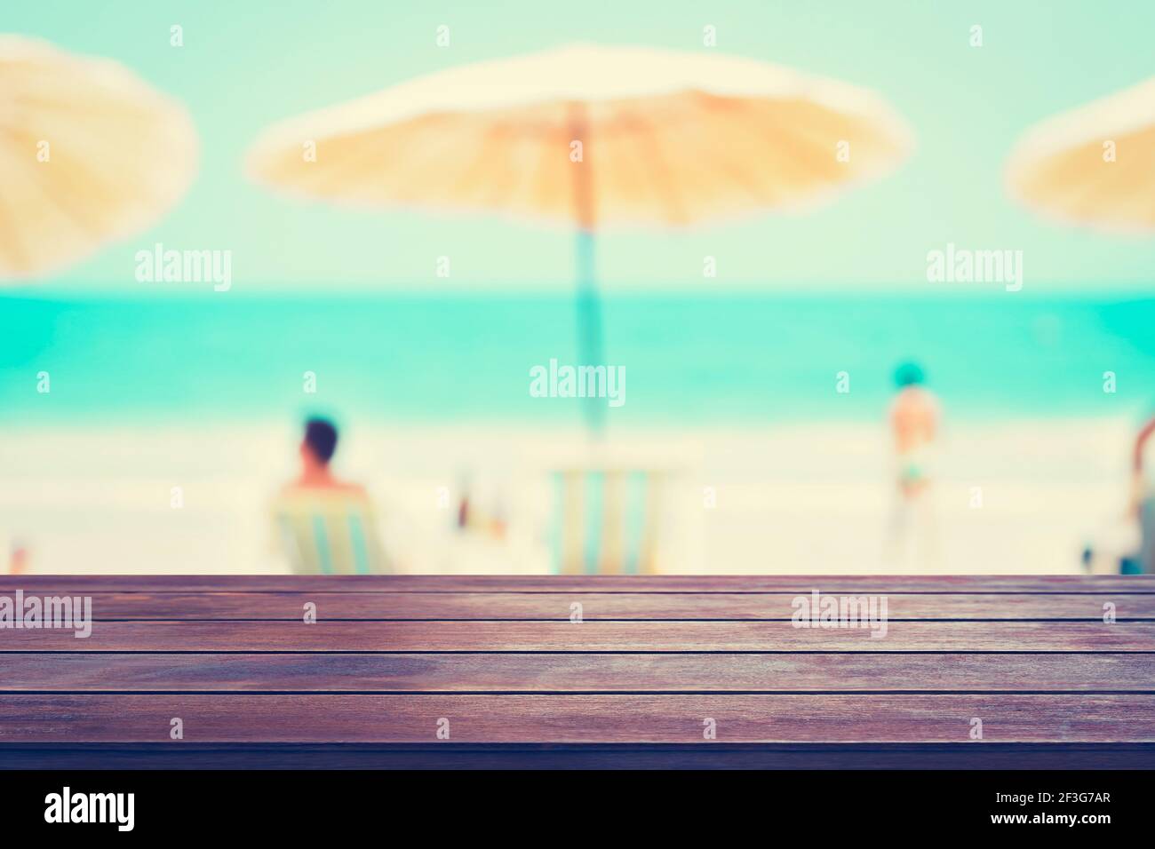 Tavolo vecchio legno su sfondo spiaggia sfocato, concetto di vacanza estiva, tonalità vintage - può essere utilizzato per montaggio o visualizzazione dei vostri prodotti Foto Stock