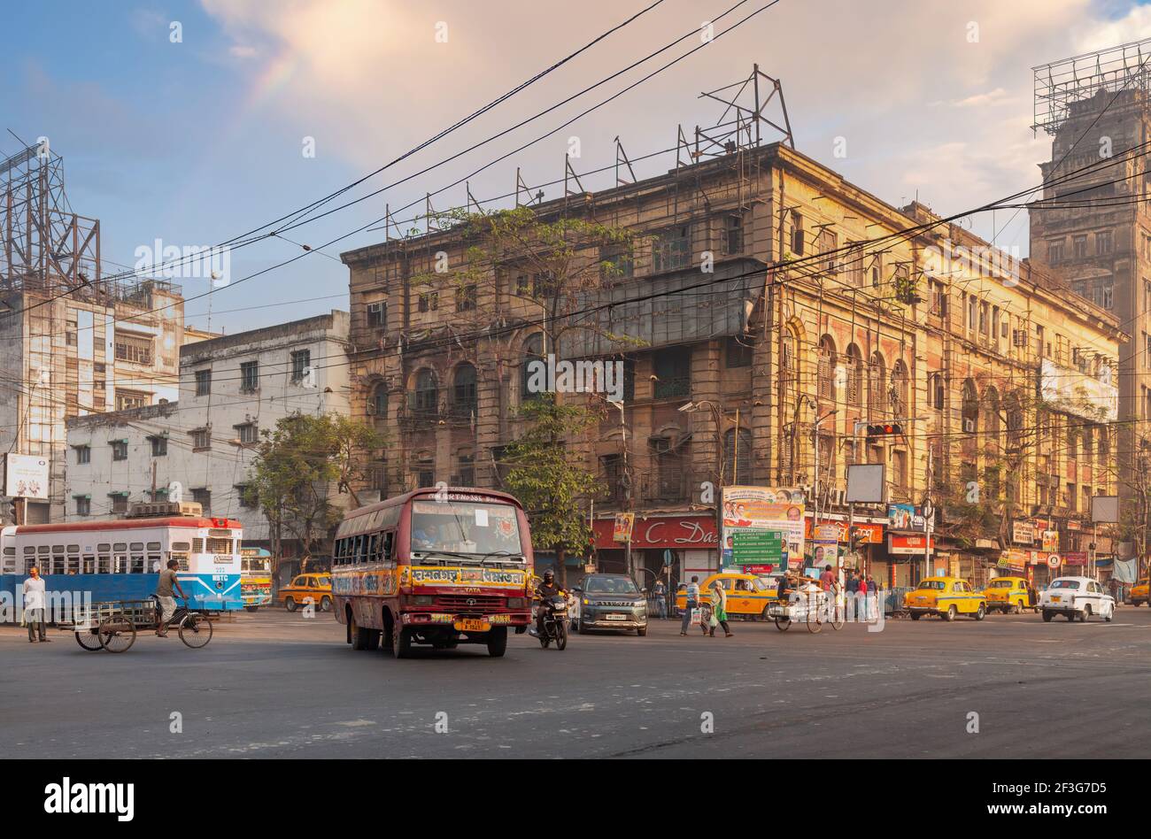 Intersezione stradale della città con i mezzi di trasporto pubblico e vista degli edifici degli uffici nella zona Chandni Chowk di Kolkata, India Foto Stock