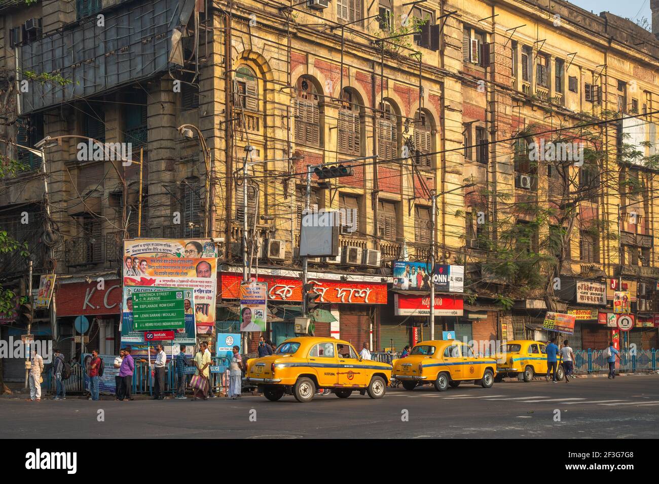 Taxi giallo in attesa di passeggeri al passaggio della strada cittadina con Vista del vecchio edificio del governo a Kolkata India Foto Stock