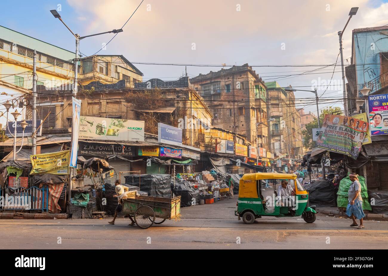 Mercato della città vecchia con bancarelle e vista su una strada auto rickshaw in attesa di passeggeri nella zona di Dharamtala di Kolkata India Foto Stock