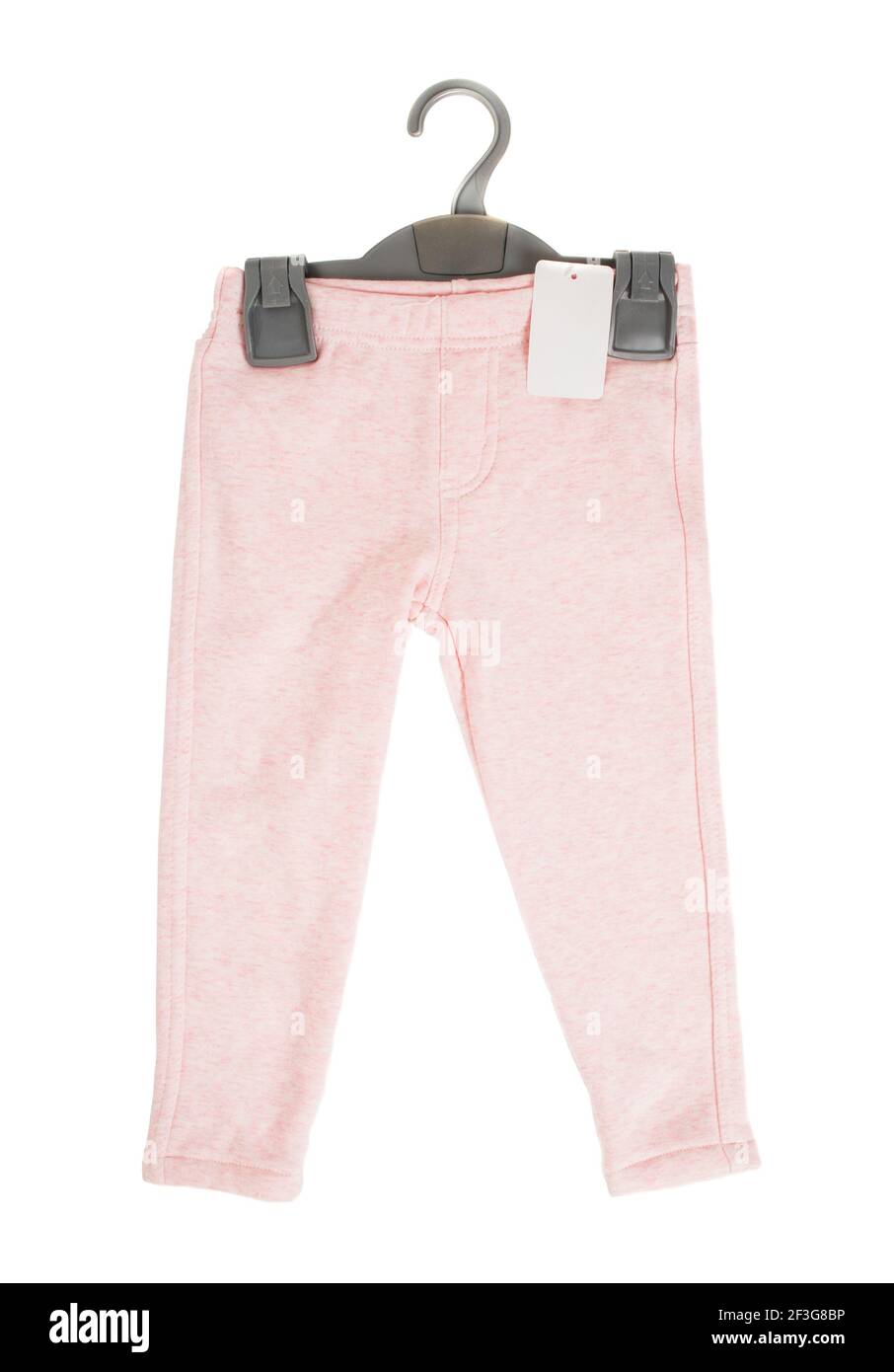 Pantaloni sportivi in cotone rosa per bambini con appendiabiti in plastica nera. Isolato su sfondo bianco. Foto Stock