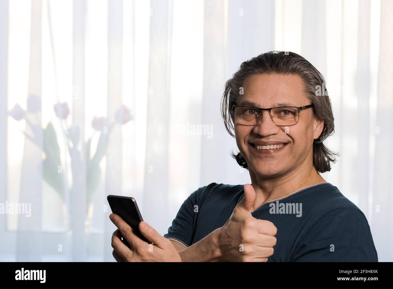 Un uomo adulto indossa i bicchieri per la vista. Gioia sul viso. Primo piano Foto Stock