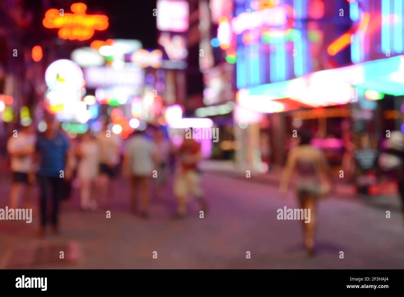 Sfondo colorato offuscato dalla strada a piedi notturna con persone a piedi e vivida luce al neon di club e bar - Pattaya, Thailandia Foto Stock