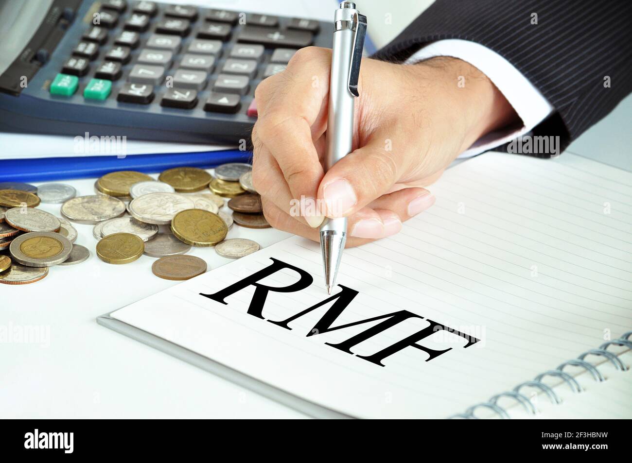 Mano di uomo d'affari con penna che punta al RMF (Fondo di investimento mutualistico di pensione) firmare sulla carta Foto Stock