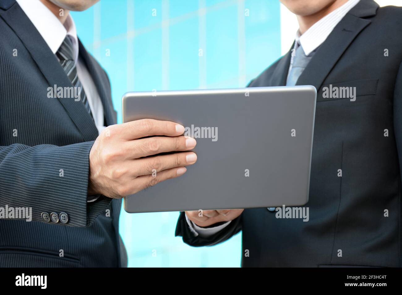 Due uomini d'affari che guardano al tablet pc - concetto di discussione aziendale Foto Stock