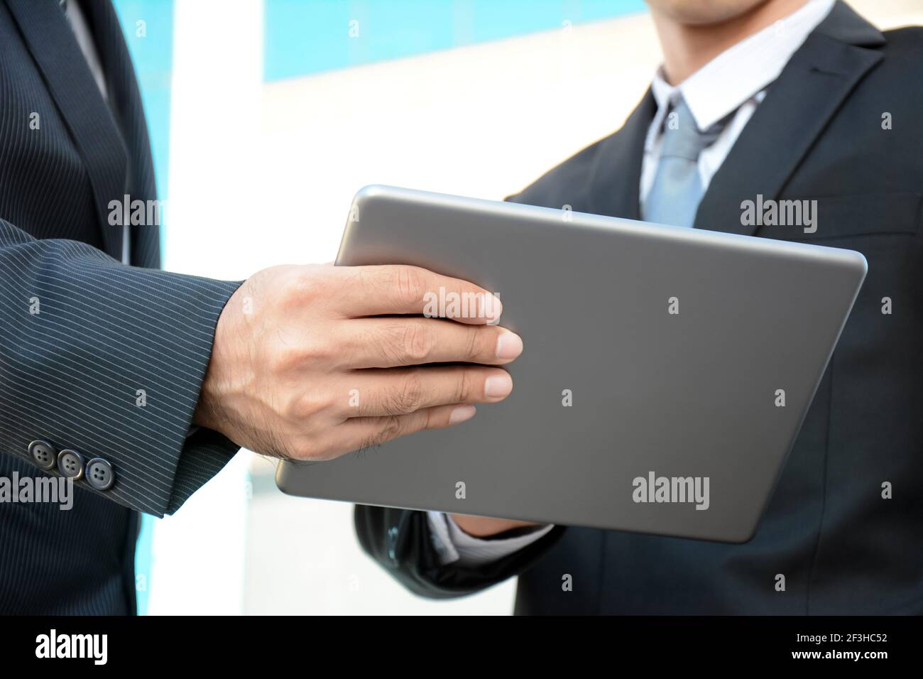 Due uomini d'affari che guardano al tablet pc - concetto di discussione aziendale Foto Stock