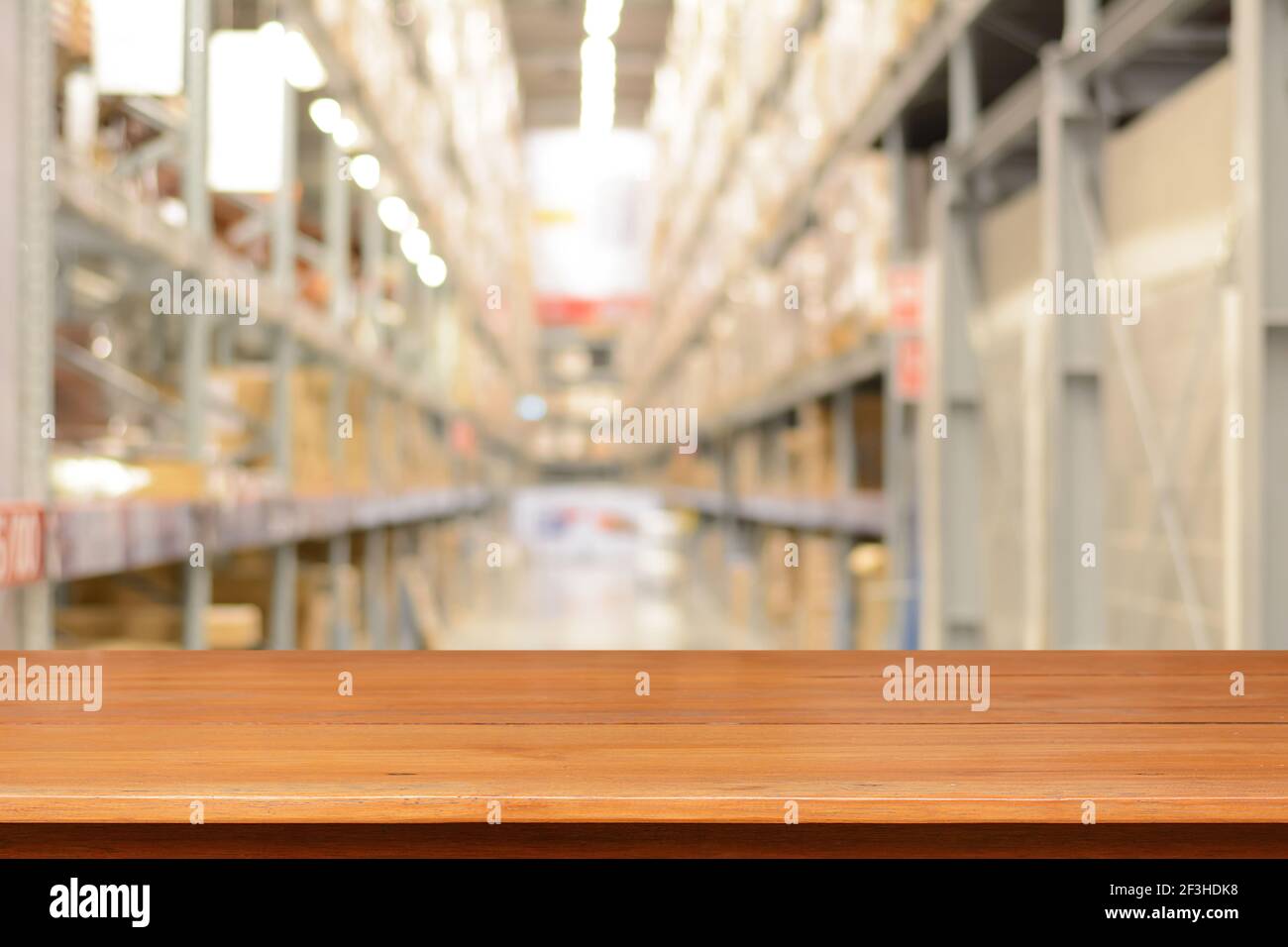 Tavolo vuoto in legno o ripiano su sfondo sfocato di magazzino Foto Stock