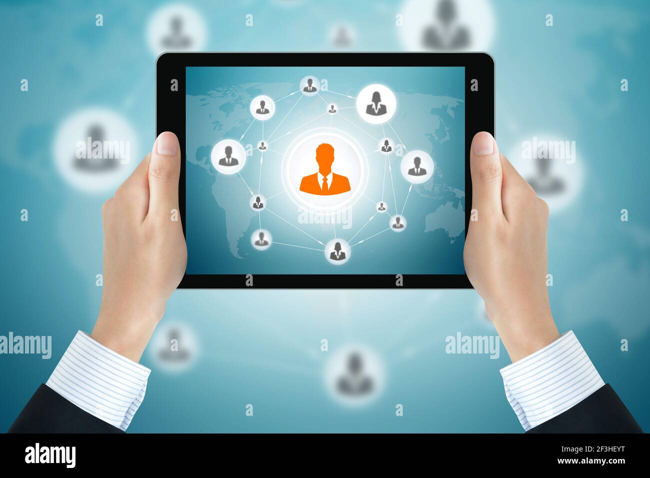 Un uomo d'affari tiene il tablet pc con le icone degli uomini d'affari collegate come rete sullo schermo - business online e social network concetti Foto Stock