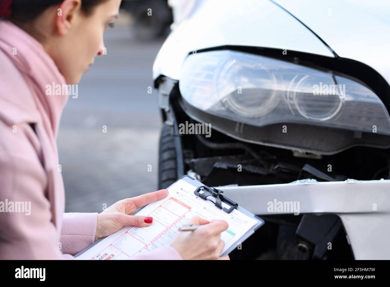 Un agente assicurativo descrive i danni al veicolo a motore Foto Stock