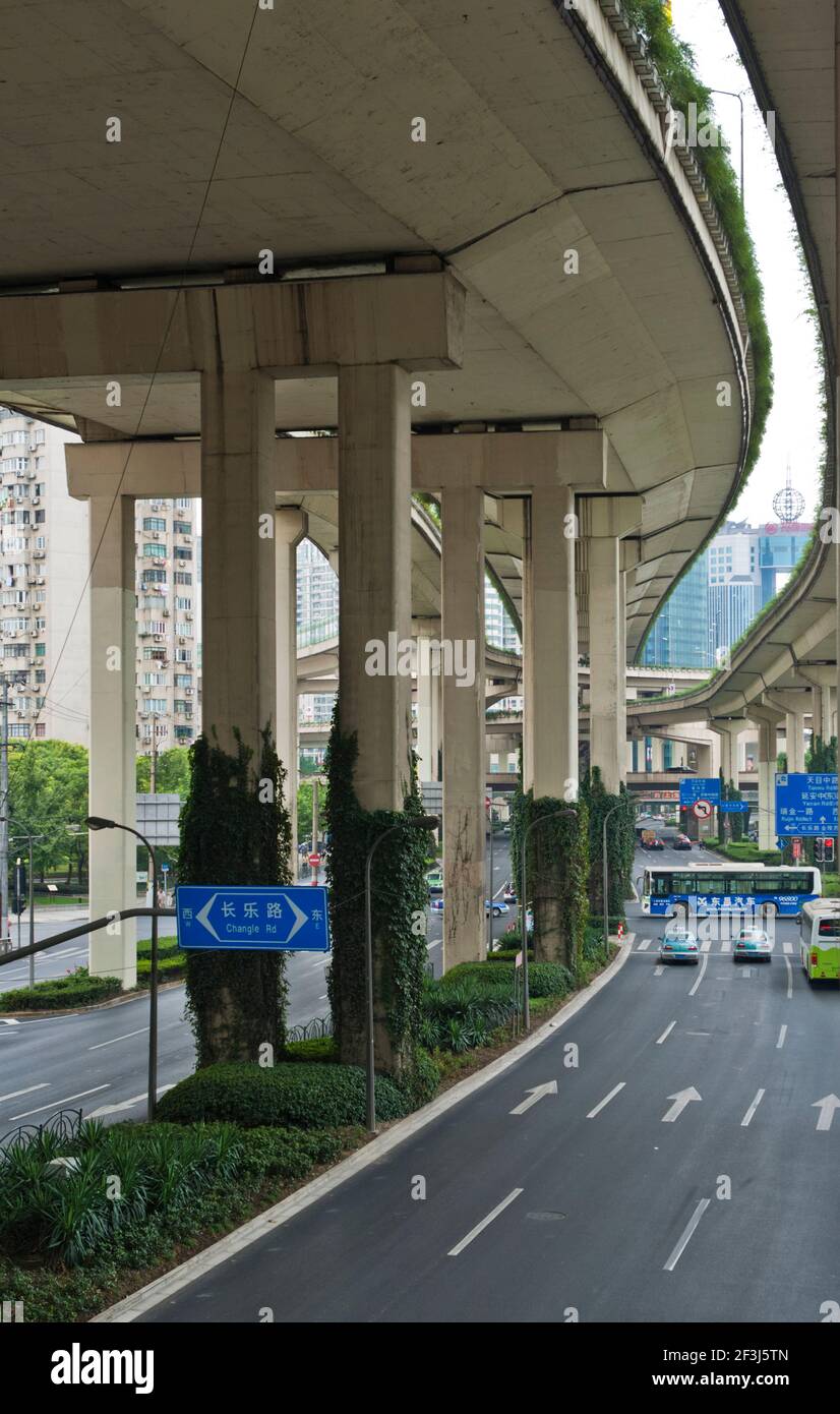 Vista da sotto il multi-lane autostrada sollevata nel centro di Shanghai in Cina, con il bus attraversando intersezione. Foto Stock