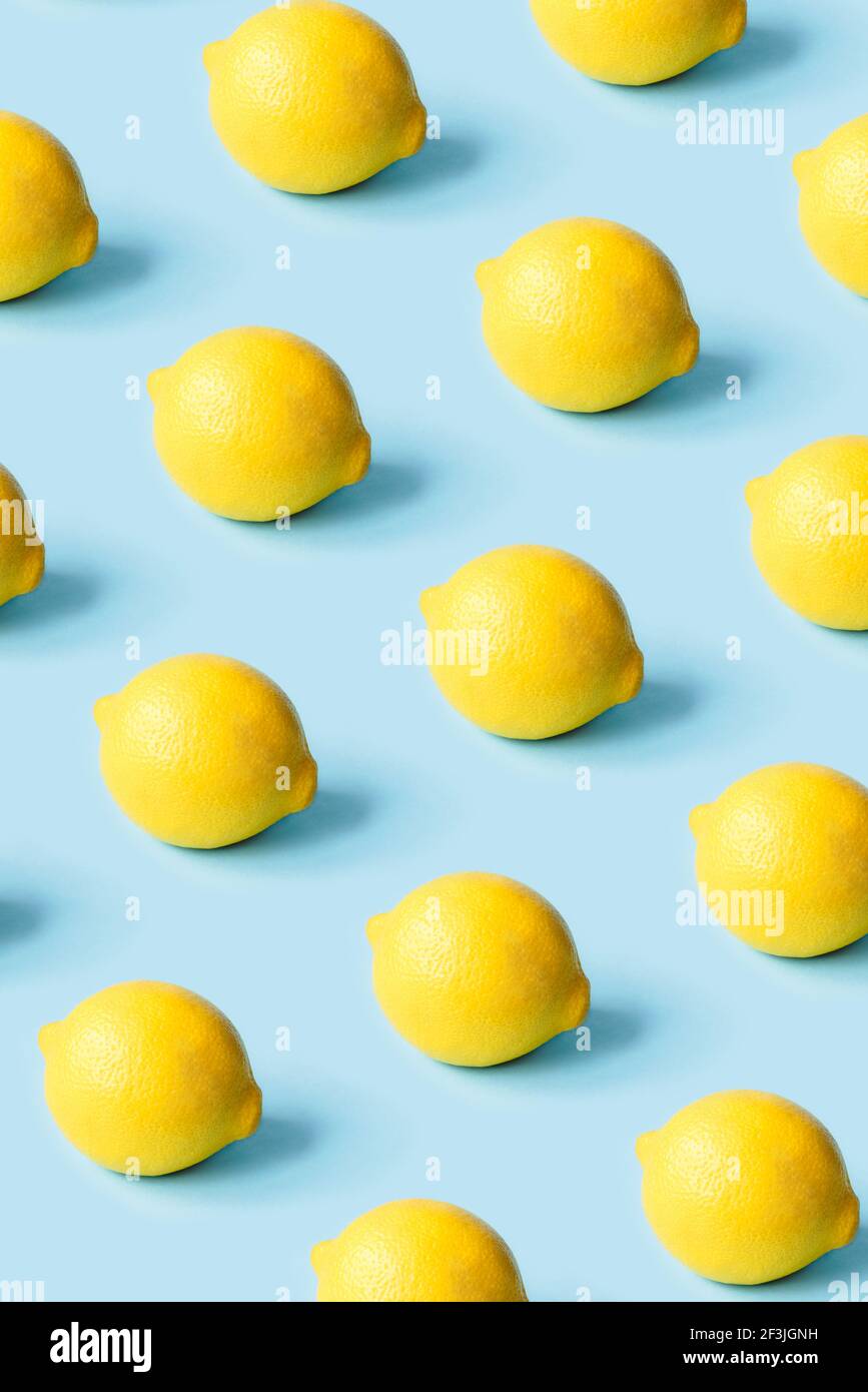 Modello di limoni maturi su sfondo blu. Foto Stock