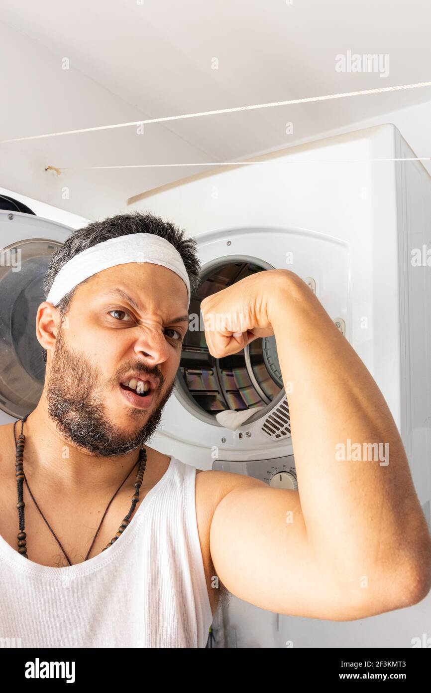 Giovane uomo con archetto che va lavare la vostra lavanderia sporca Foto Stock