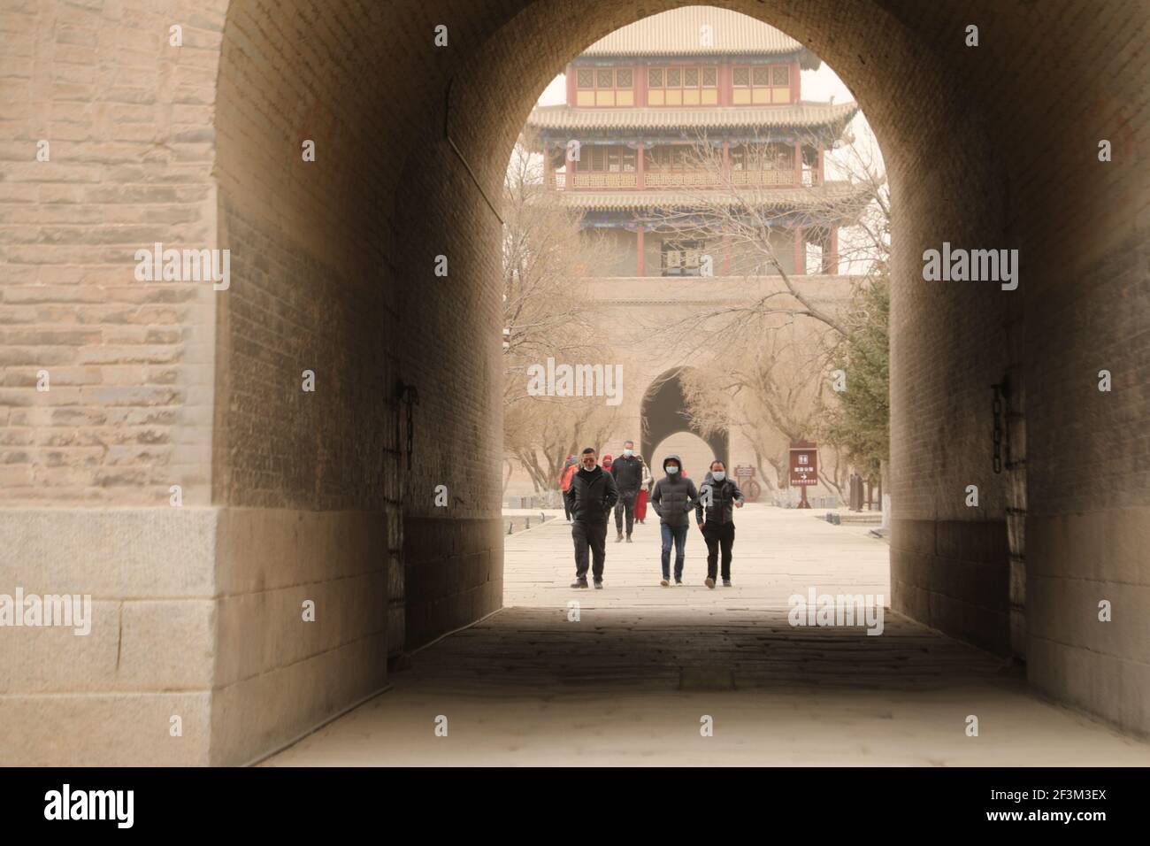Jiayuguan, provincia cinese di Gansu. 17 Marzo 2021. I turisti visitano il Passo di Jiayu nella città di Jiayuguan, nella provincia di Gansu, nella Cina nord-occidentale, il 17 marzo 2021. Alcune aree del Corridoio Hexi, parte dell'antica Via della Seta nel nord-ovest della Cina, sono state coperte da sabbia galleggiante e polvere mercoledì. Credit: Zhang Zhimin/Xinhua/Alamy Live News Foto Stock