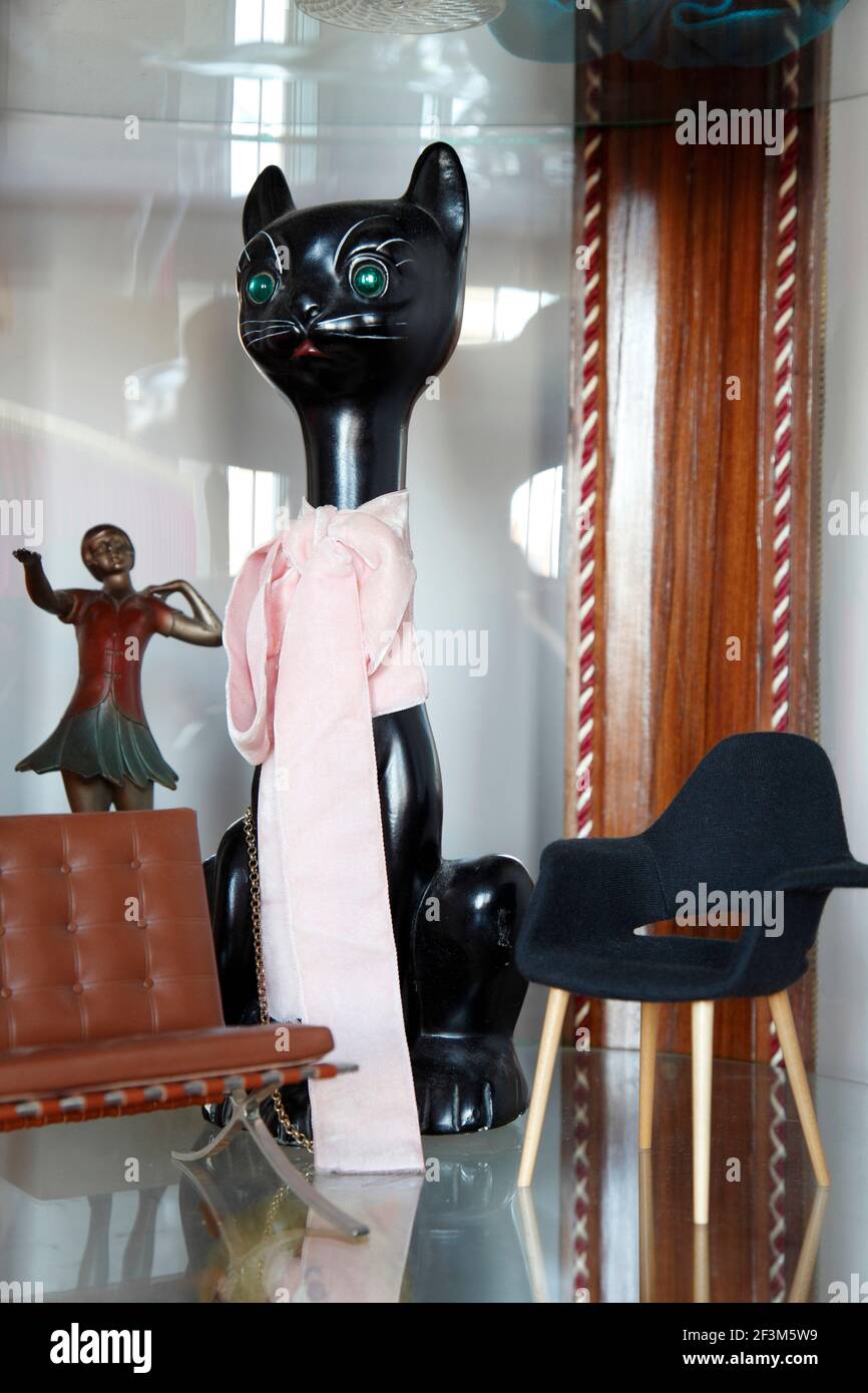 Gatto nero in ceramica con arco rosa, ballerino anni '20, e sedie  moderniste in miniatura in vetrina | NESSUNO | Foto stock - Alamy
