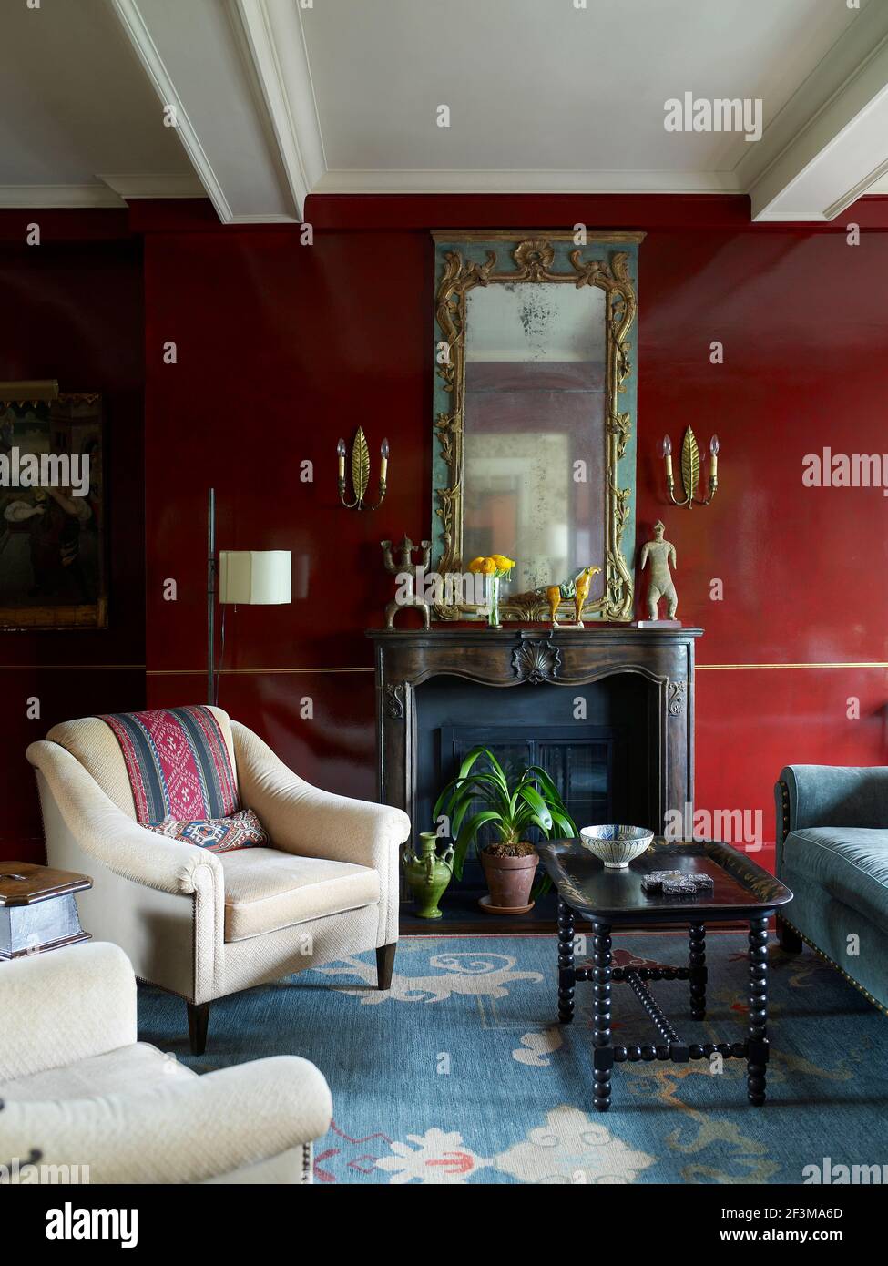 Il soggiorno è con sedie a sdraio e tavolino accanto al camino con grande  specchio ornato e luci da parete in casa residenziale americana Foto stock  - Alamy