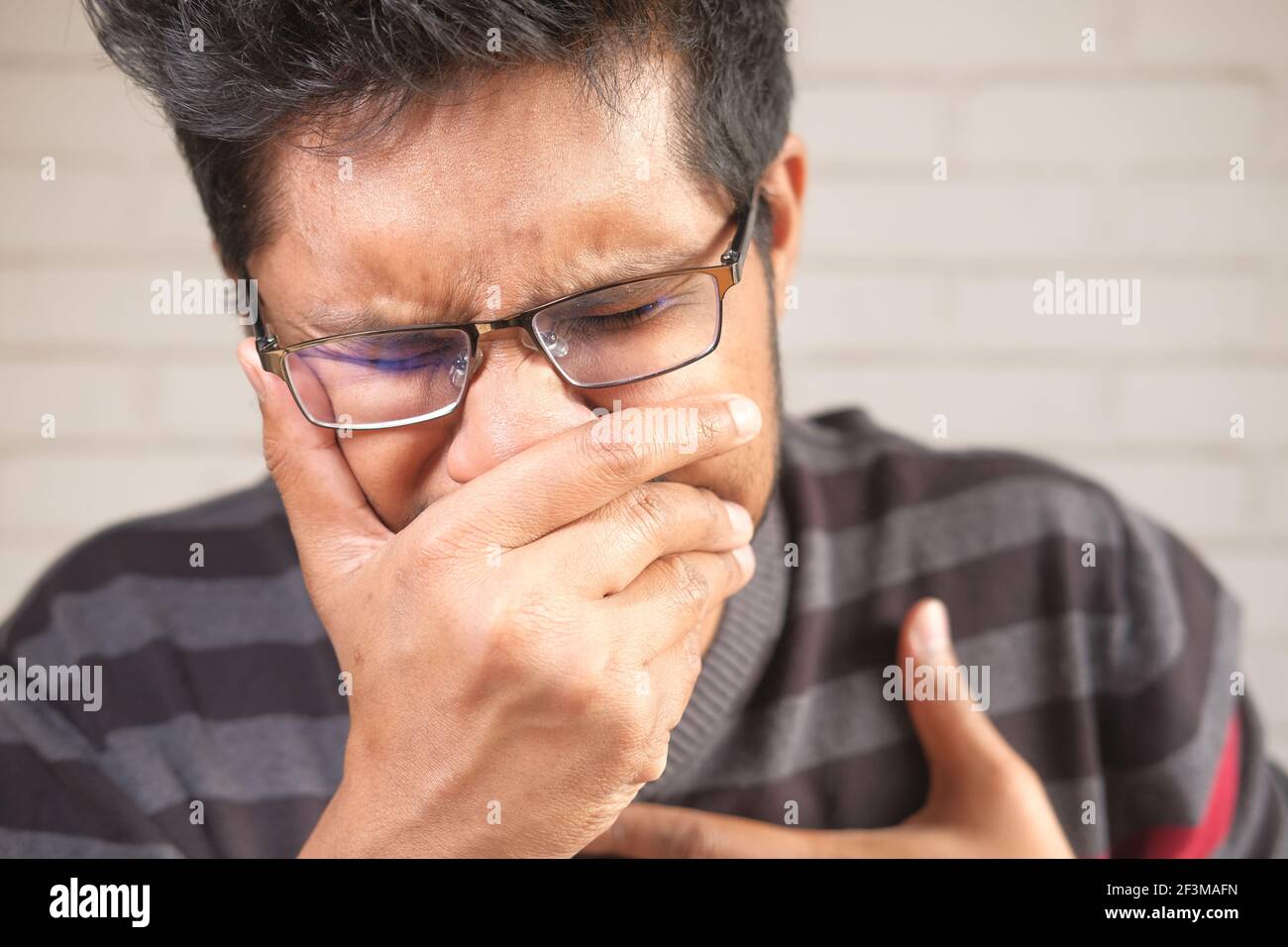 giovane asiatico tosse e starnuti da vicino Foto Stock