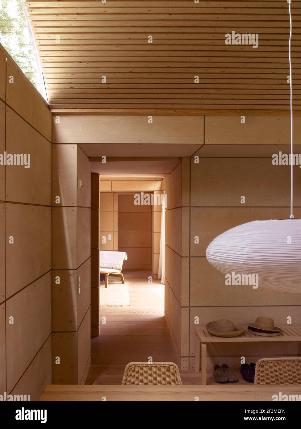 Lampada a sospensione in camera con pareti rivestite in legno di colore fawn e soffitto curvo in una casa residenziale, Danimarca Foto Stock