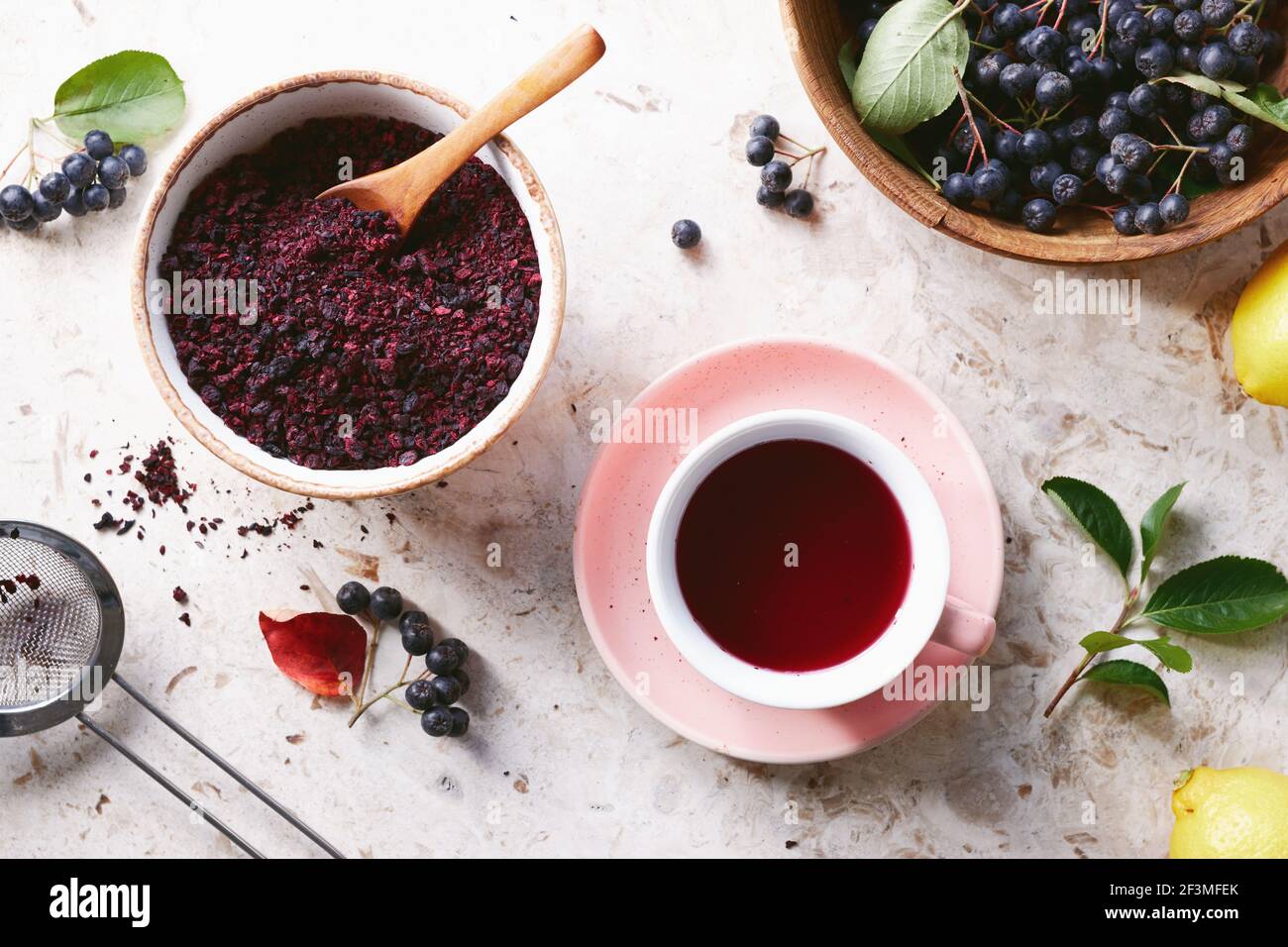 Tè alle bacche di Aronia in una tazza. Le bacche aroniche secche sono comunemente usate per fare il tè alle erbe ricco di antiossidanti. Foto Stock