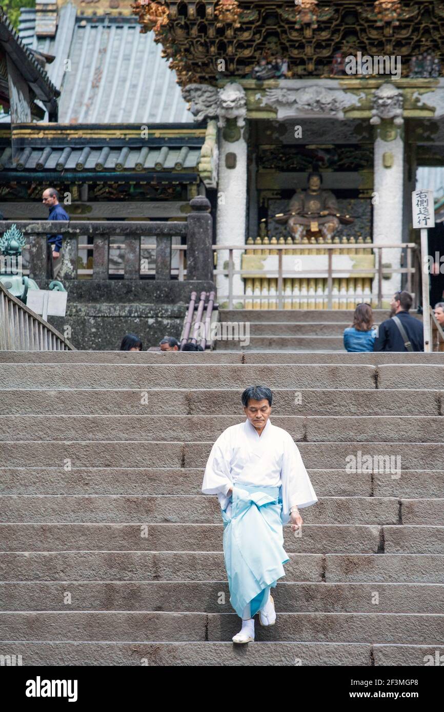 Il sacerdote giapponese scende ripidi scalini al Santuario Nikko Tosho-GU Shinto, sito patrimonio dell'umanità dell'UNESCO, Nikko, Giappone Foto Stock