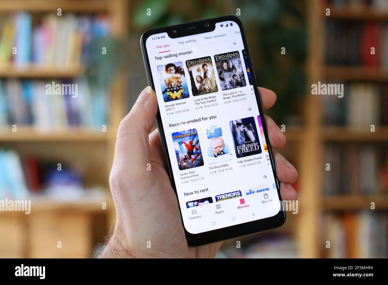 VARSAVIA, POLONIA - 29 GENNAIO 2021: Utente che naviga i film per il noleggio in video-on-demand Google Play servizio store su un sistema operativo Android, Xiaomi brand smart pho Foto Stock