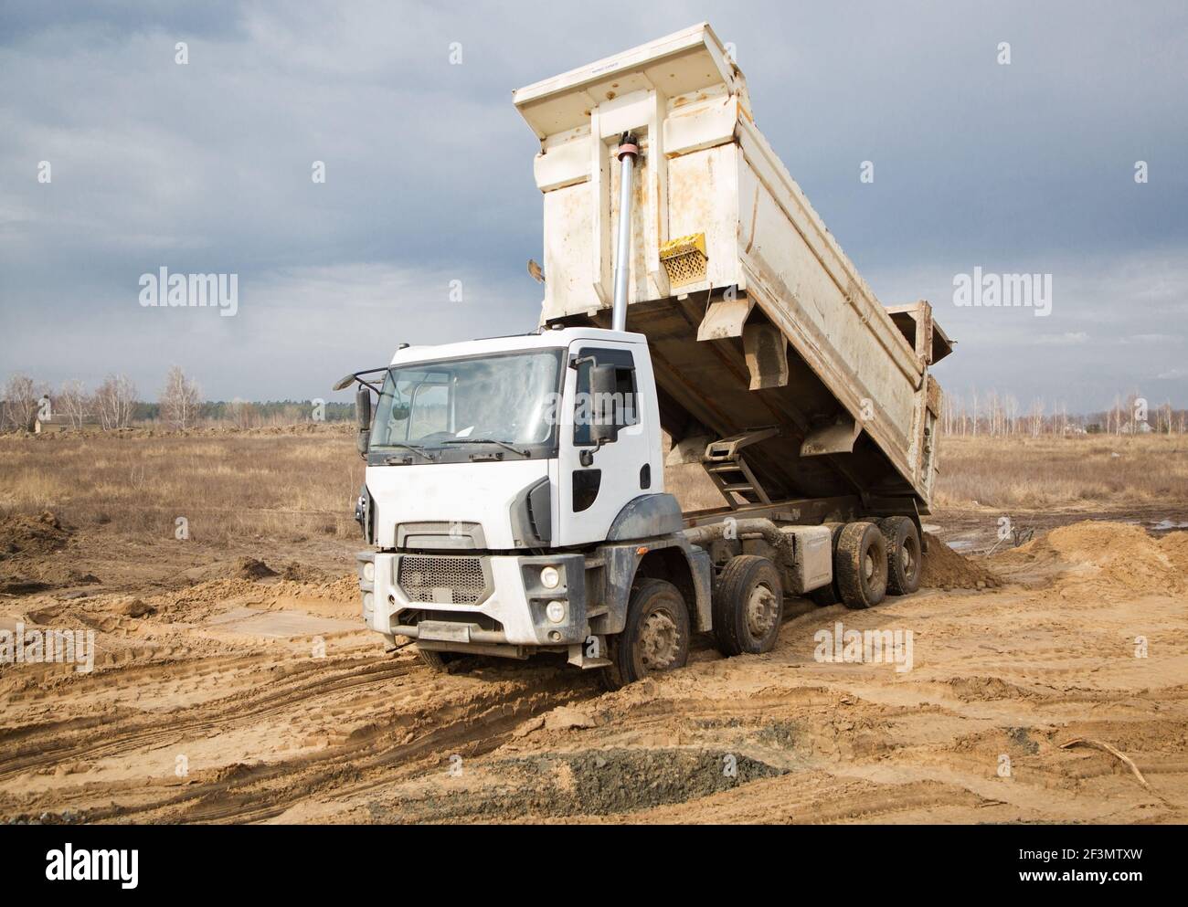 il dumper da cantiere esegue lavori di terra in cantiere. Scaricare il terreno. Lavori preparatori sulla costruzione Foto Stock