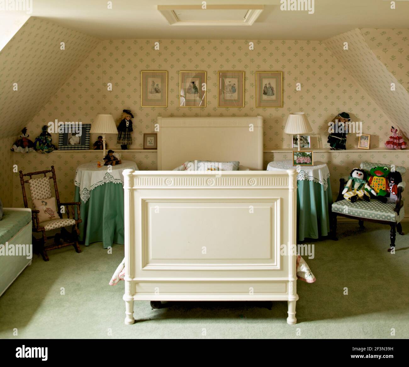 Camera da letto mansardata per bambini con letto singolo bianco e carta da parati a motivi Foto Stock