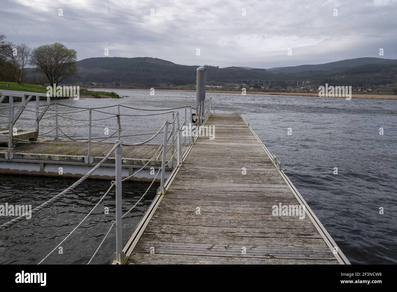 Vista su un molo in legno con ringhiere bianche il mare Foto Stock