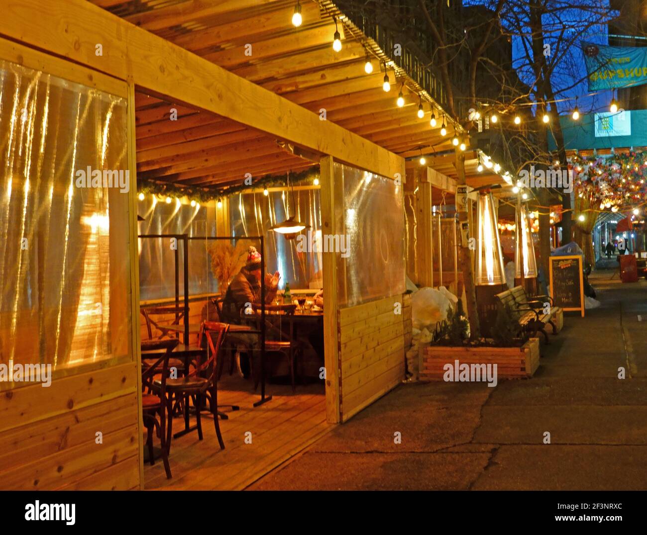 Due clienti maschi che mangiano in un rifugio all'aperto, Manhattan, New York Foto Stock