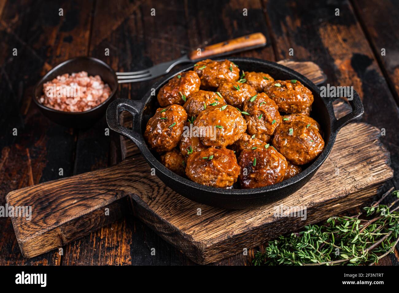 Polpette in salsa di pomodoro di manzo e carne di maiale con timo in padella rustica. Sfondo scuro. Vista dall'alto Foto Stock