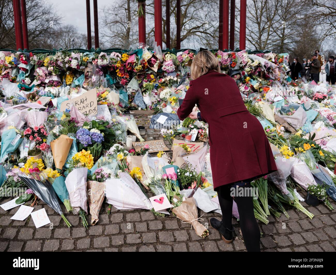 Un pianista mette fiori e candele per Sarah Everard alla tribuna di Clapham Common, 14 marzo 2021 Foto Stock