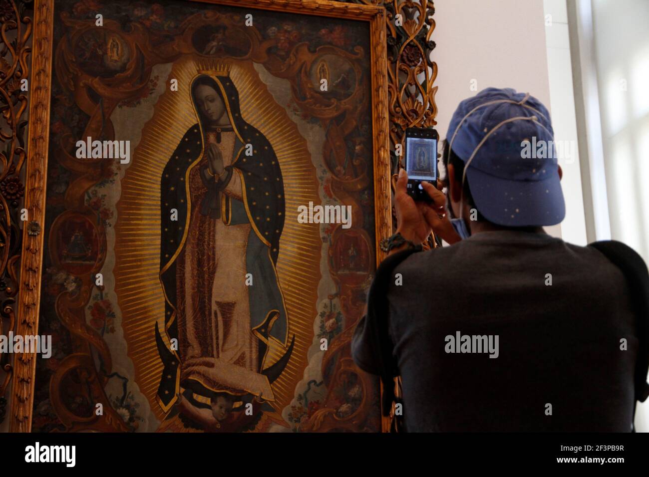Non esclusivo: CITTÀ DEL MESSICO, MESSICO - 16 MARZO: Una persona scatta una foto a una pittura della Vergine di Guadalupe durante un tour all'interno del Museo Munal, in mezzo all'ora Foto Stock