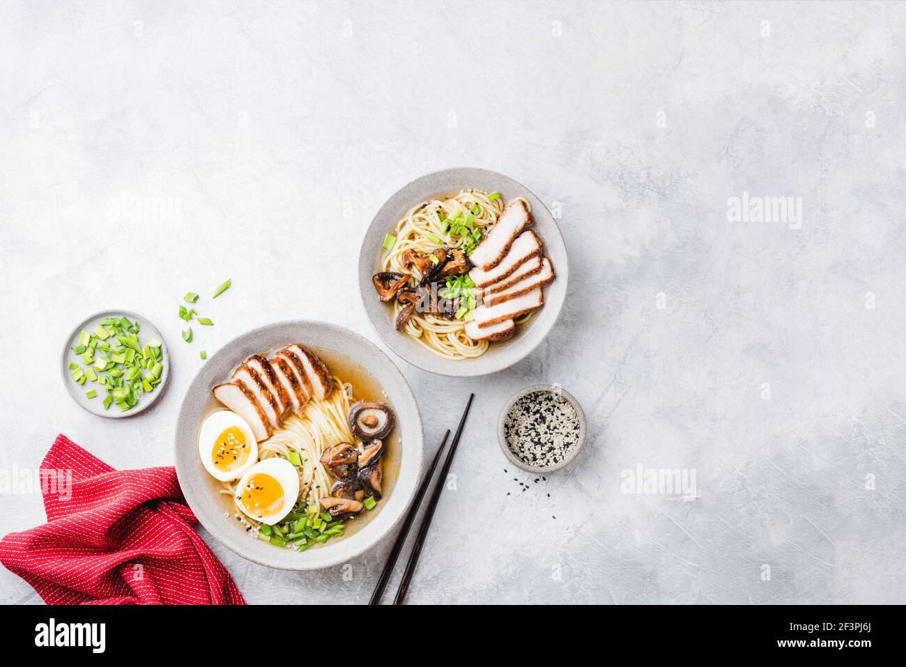 Spaghetti di pollo ramen in una ciotola su sfondo grigio di cemento. Vista dall'alto del tavolo. Cucina asiatica Foto Stock