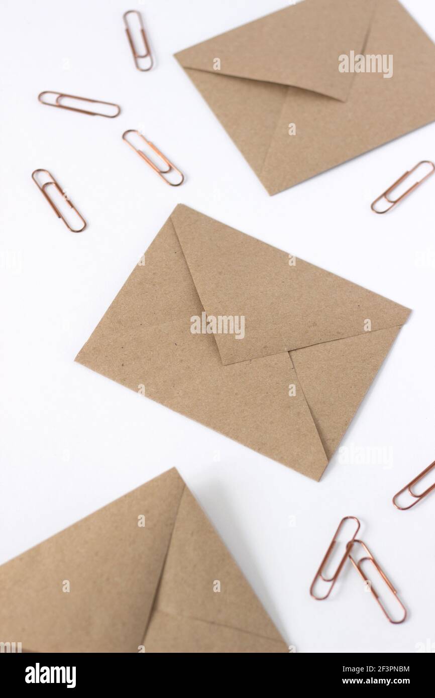 Background creativo aziendale. Buste e clip disposte su bianco. Mockup dal design minimale. Foto Stock