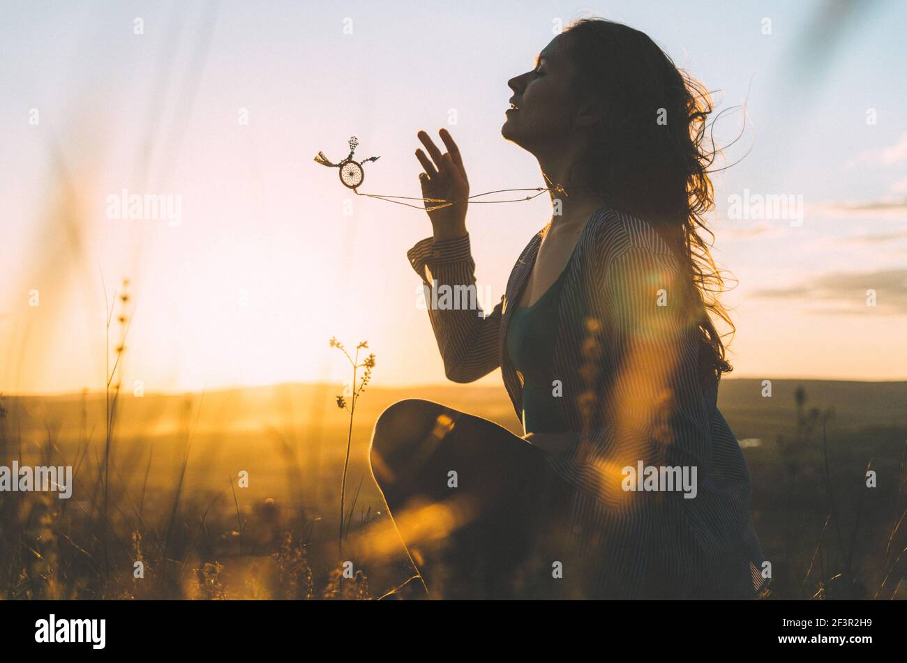 Ritratto di una giovane donna al tramonto con la bella balinese collana a geometria sacra in movimento Foto Stock