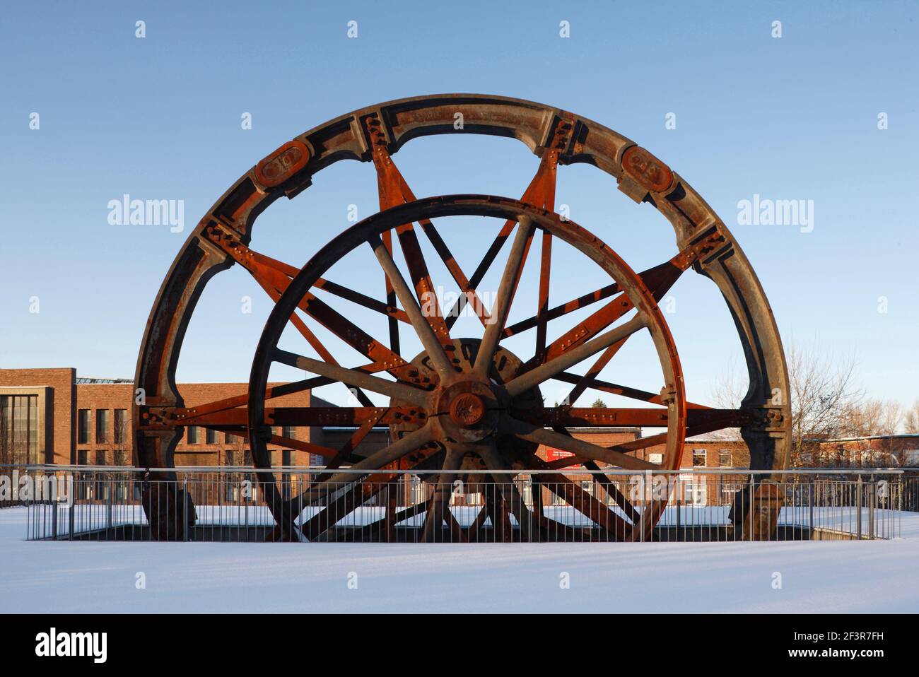 Grande volano circondato da neve al Museo dell'industria, di Storia economica e sociale della zona di Aquisgrana a Stolberg, Germania Foto Stock