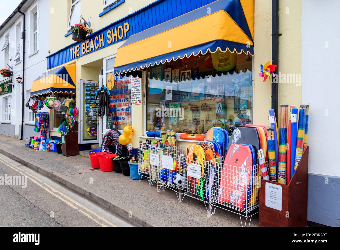 Il Beach Shop, vendita di souvenir di vacanza, frangivento, tavole da corpo, secchi, Spades e altri giocattoli da spiaggia, sul lungomare di Westward ho!, Devon, Regno Unito Foto Stock