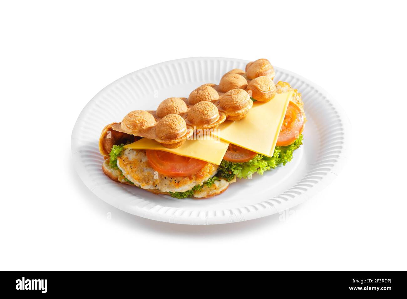 Waffle a bolle d'aria di Hong Kong. Farcire la cialda con formaggio, pollo fritto, pomodoro e insalata su un piatto di carta isolato su sfondo bianco. Foto Stock