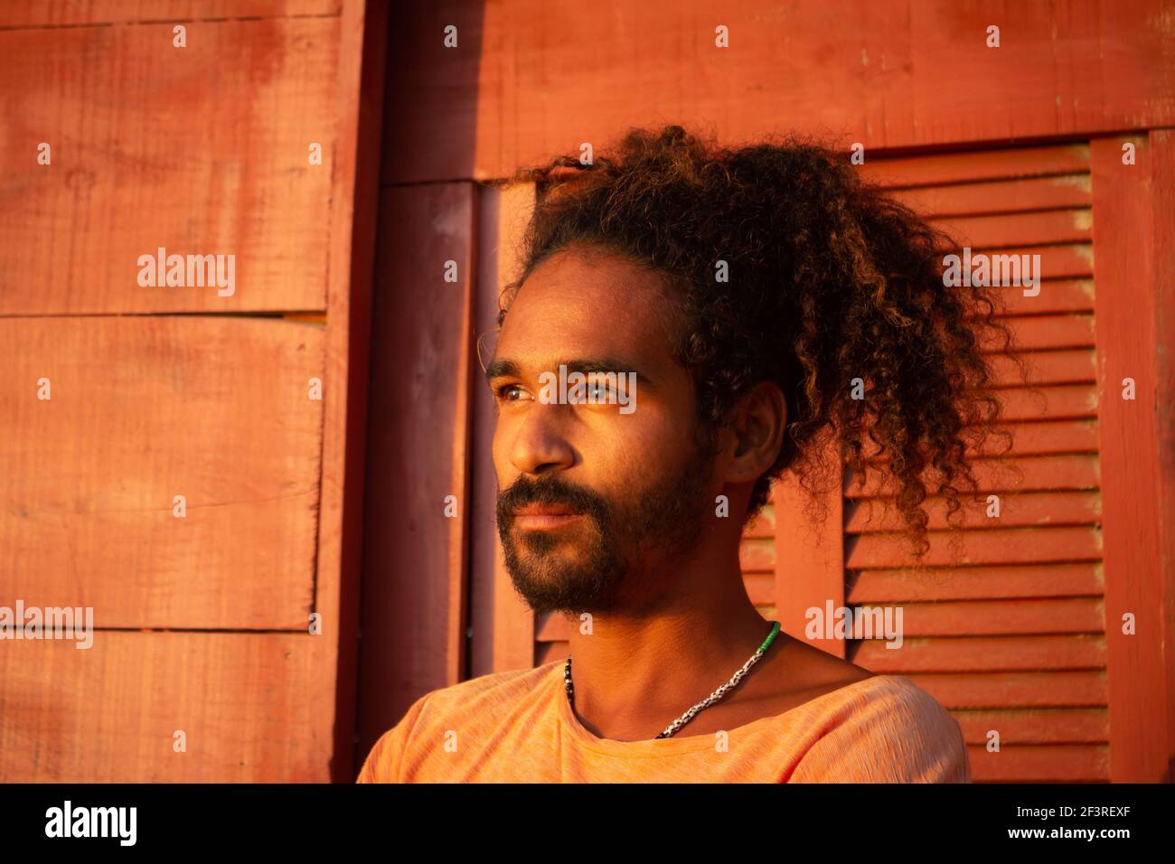 Triste uomo nero. Lunghi capelli ricci su un giovane di etnia brasiliana. Concetto di tristezza pandemica e ansia. Uomo bearded Foto Stock