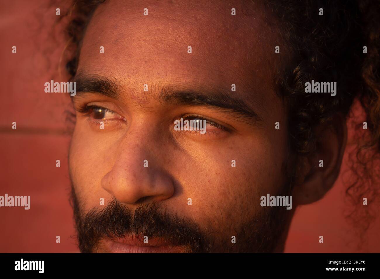 Triste uomo nero. Lunghi capelli ricci su un giovane di etnia brasiliana. Concetto di tristezza pandemica e ansia. Uomo bearded Foto Stock