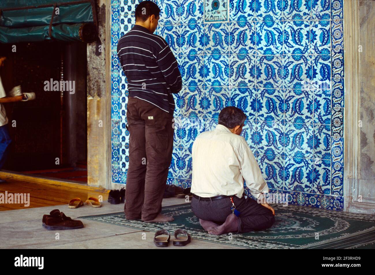 Istanbul Turchia uomini che pregano al muro di piastrelle di Iznik Rustem Pasha Camii Foto Stock