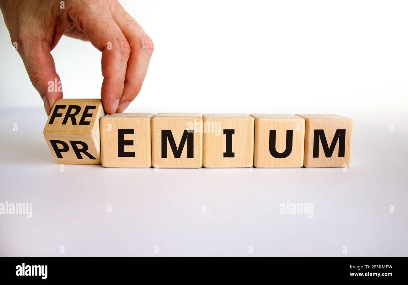 Simbolo Premium o freemium. Uomo d'affari trasforma il cubo di legno e cambia la parola 'premium' in 'freemium'. Splendido sfondo bianco. Affari, prem Foto Stock