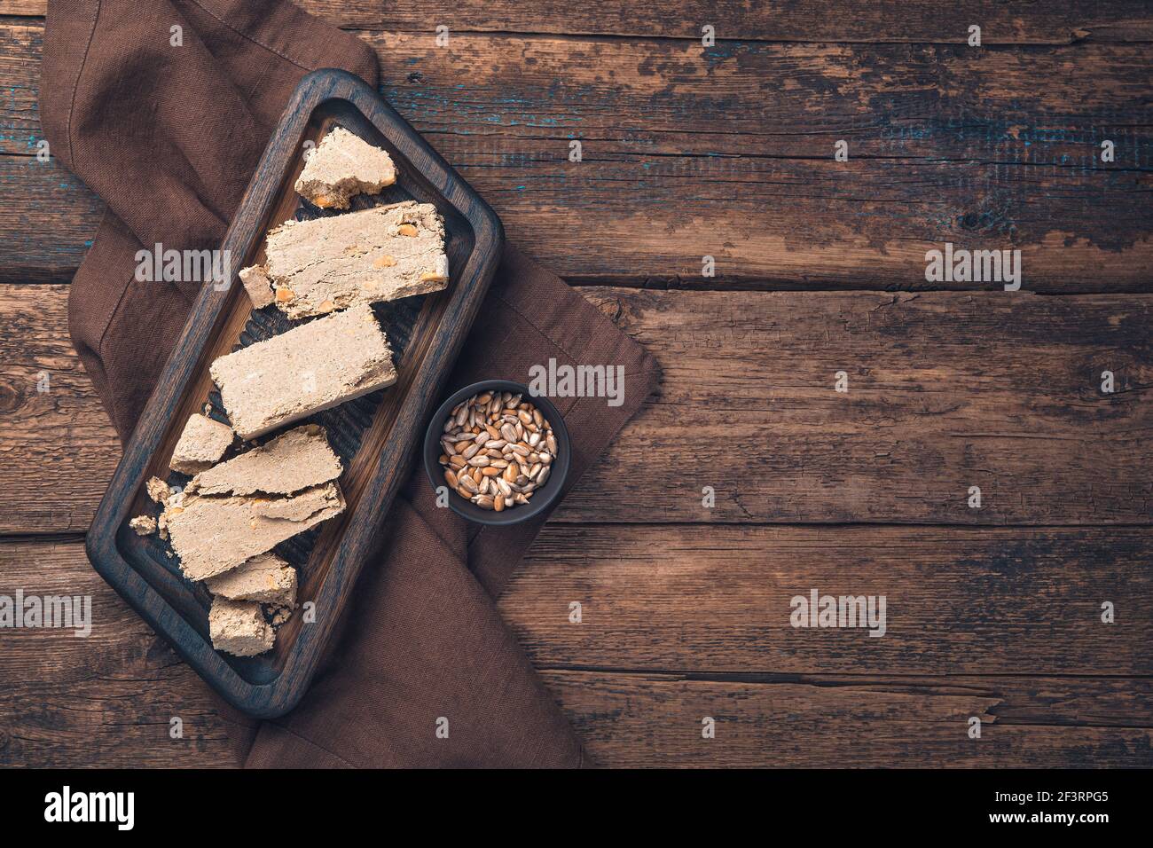 Halva con semi di girasole su sfondo marrone. Vista dall'alto con spazio per la copia. Foto Stock