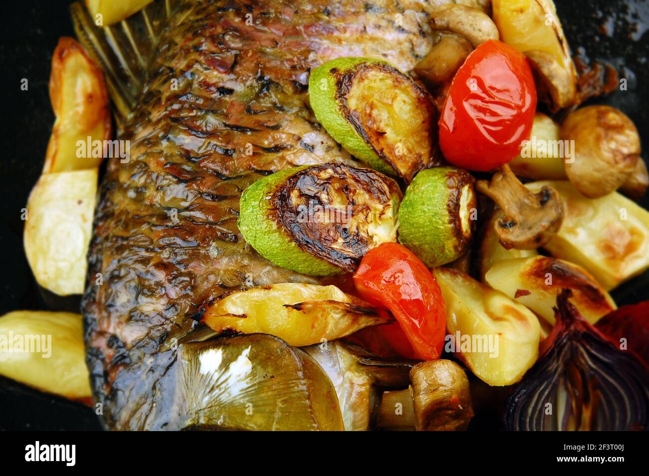 Pesce al forno con verdure, funghi e limone. Mettere a fuoco un'immagine centrale. Foto Stock