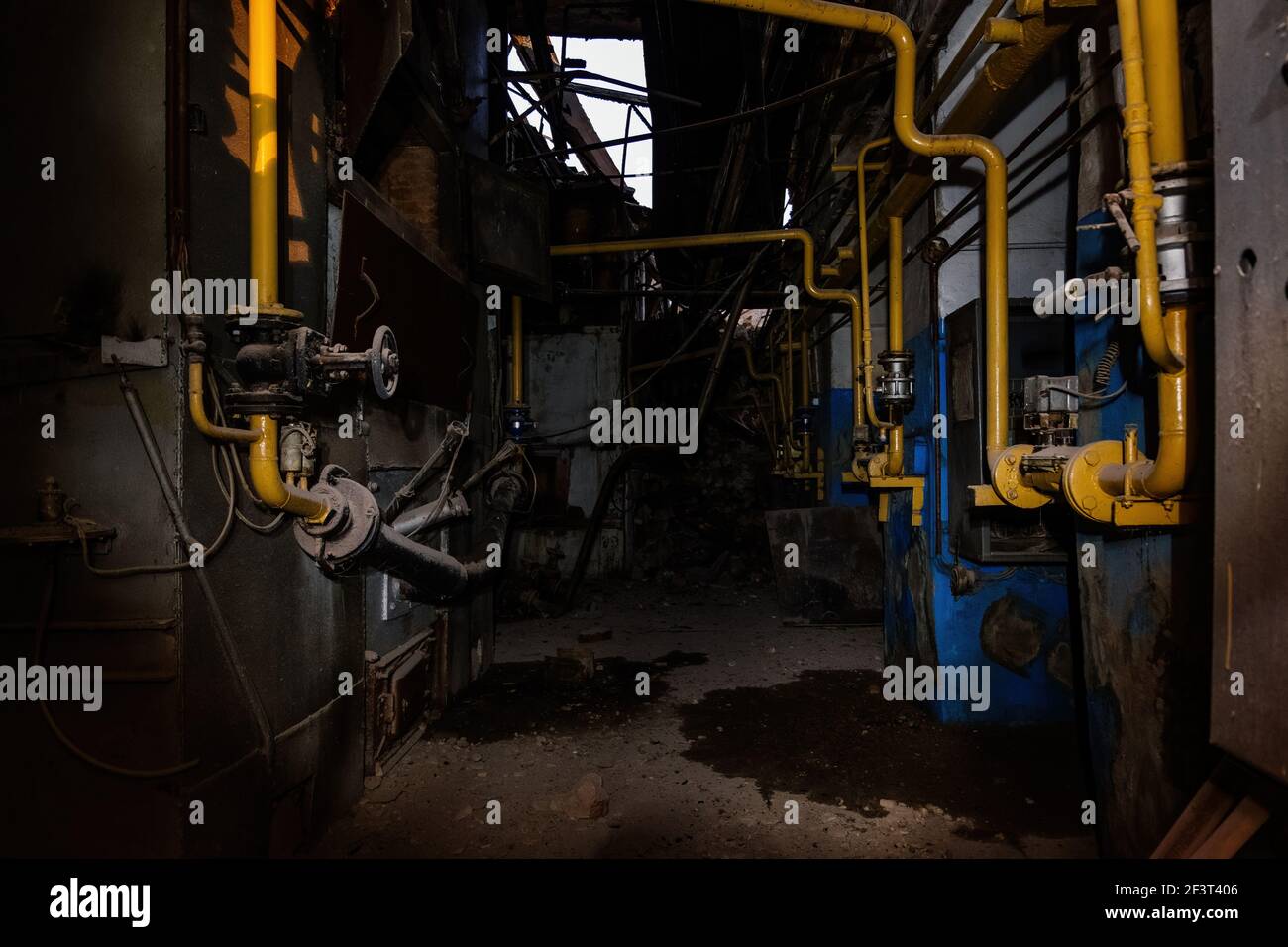 All'interno di un vecchio edificio industriale crollato. Vecchia pipeline arrugginita Foto Stock