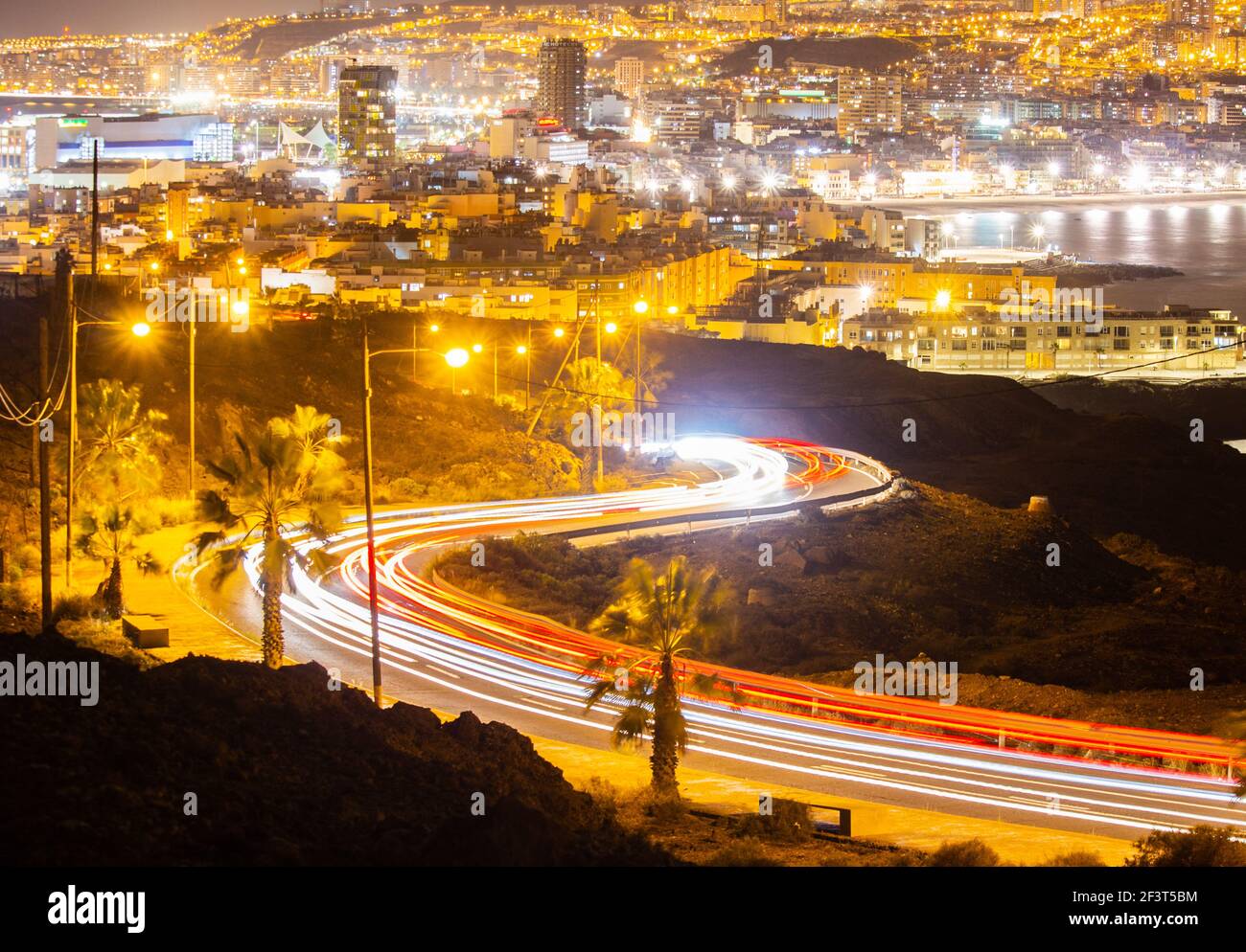 Las Palmas, Gran Canaria, Isole Canarie, Spagna. 17 marzo 2021. Vista sulla città di Las Palmas di notte con i sentieri per le luci dell'auto che illuminano la strada serpente in primo piano. Credit: Alan Dawson/Alamy Live News. Foto Stock